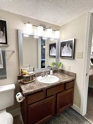 Apartment kitchen with black appliances and wooden cabinetry at The Abbey at Riverchase in Hoover, Alabama