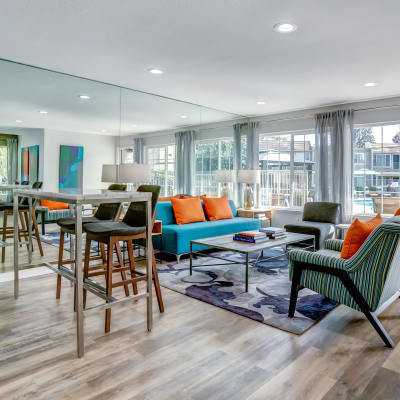 Spacious community lounge and clubhouse with natural light coming from large windows at Sofi at Los Gatos Creek in San Jose, California
