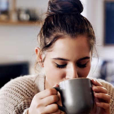 Resident enjoying a warm cup of coffee near her home at London Terrace Gardens in New York, New York