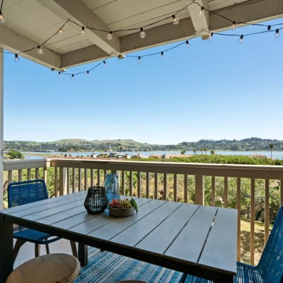 Spacious patio with outdoor furniture and beautiful bay views in a model home at Harbor Point Apartments in Mill Valley, California