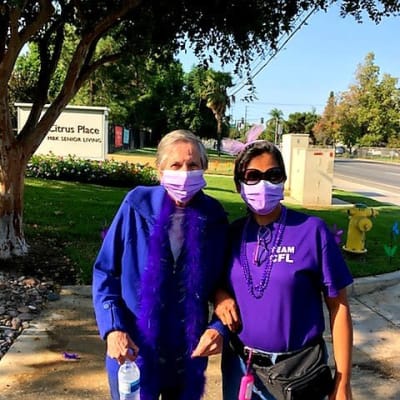 Caretaker out on a walk with a resident at Estancia Del Sol in Corona, California