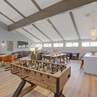Resident clubhouse with plenty of plush seating and a foosball table ready to play at Sofi Ventura in Ventura, California