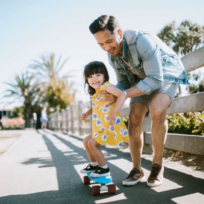 a father teaching his daughter to skateboard at Copper Canyon in Twentynine Palms, California