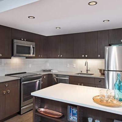 Contemporary design in a model home's kitchen with stainless steel appliances at Panorama Apartments in Seattle, Washington