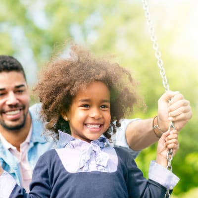 a father and daughter playing on the swings at Shelton Circle in Virginia Beach, Virginia