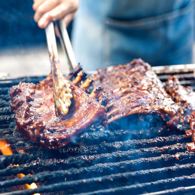 a resident grilling some steak at Howard Gilmore Terrace in La Mesa, California