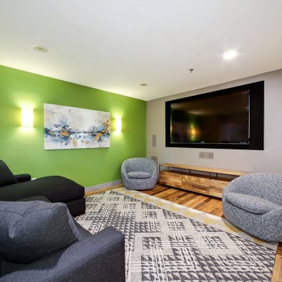 Resident lounge with a cozy couch and chairs to watch the big screen tv at Alley South Lake Union in Seattle, Washington