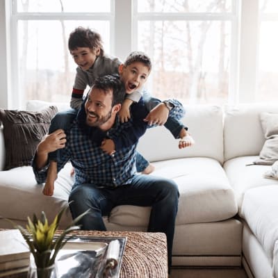 Father and sons having fun in their living room at The Oasis at Regal Oaks in Charlotte, North Carolina