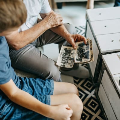 Resident showing old photos to a young child at Vernon Terrace of Edina in Edina, Minnesota