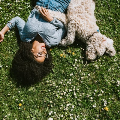 Woman and dog in the grass at Flats At 540 in Apex, North Carolina