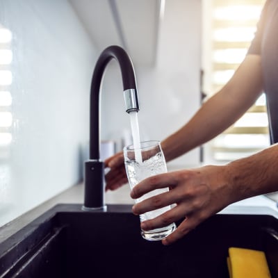 Resident pouring a glass of water in their kitchen at Mariposa at Jason Avenue in Amarillo, Texas