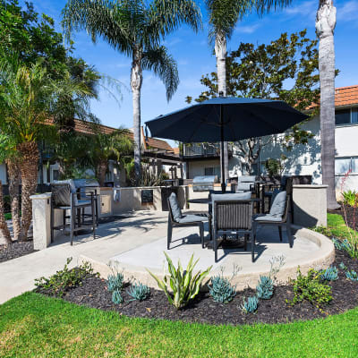 Table and chairs covered by a large umbrella by the barbecue area so you can relax in the shade on a hot day at Terra Camarillo in Camarillo, California