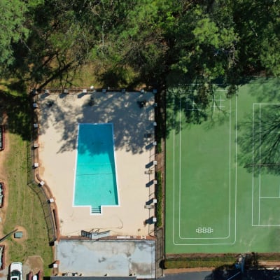 An aerial view of the community pool and tennis courts at Rivers Edge Apartments in Jonesboro, Georgia