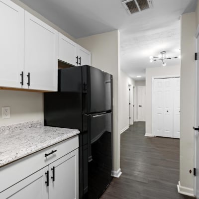 White cabinets and black appliances in an apartment kitchen at Spring Creek Apartment Homes in Decatur, Georgia