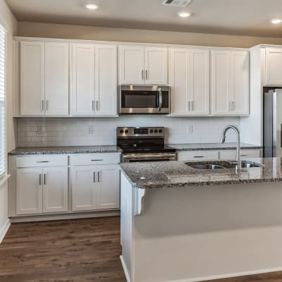 Wood flooring and granite countertops in an apartment home kitchen at Rows at Pinestone in Travelers Rest, South Carolina