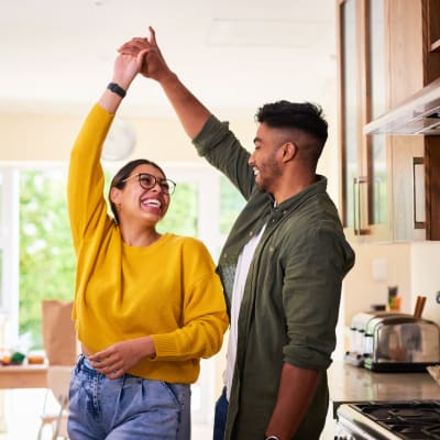 Man whirling a woman in the kitchen at Lyford Apartments in Tiburon, California