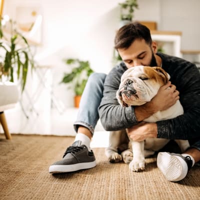 Man hugging his dog at Via Holon Apartments in Greenbrae, California