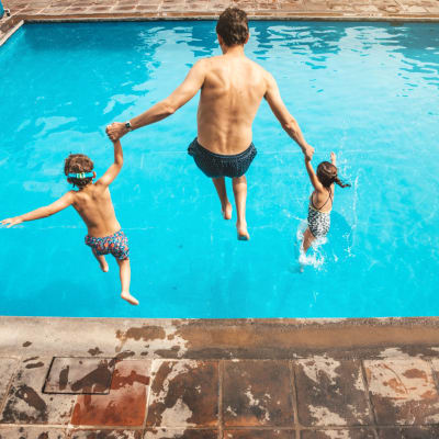 Dad and kids jumping into pool at Alannah at Westover Hills in San Antonio, Texas