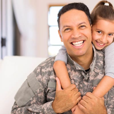 A man in a military uniform with his daughter near Towne Storage - University in Las Vegas, Nevada
