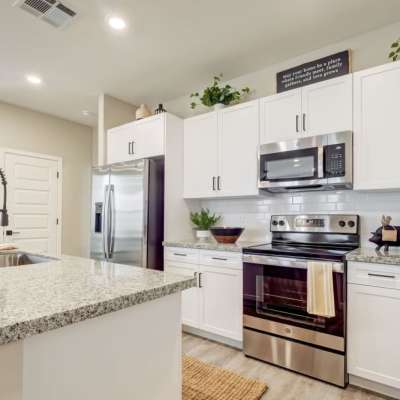 Apartment kitchen with white cabinets and stainless-steel appliances at BB Living at The Oaks in Meridian, Idaho