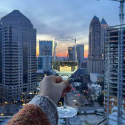 Resident holding a wine glass while looking at the city views from Vireo in Atlanta, Georgia