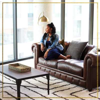 Resident enjoying the city view from her couch at Gentry in Atlanta, Georgia