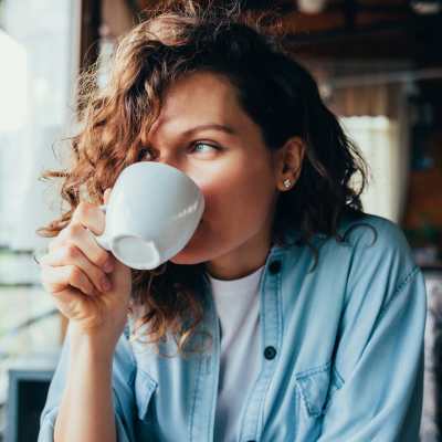 Resident woman drinking coffee near Hoff Mall and Hoff Apartments in Mount Horeb, Wisconsin