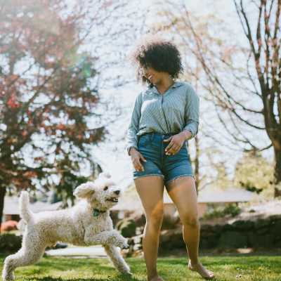 Resident playing with dog  in park nearby The Residences at Creighton Waterway in North Port, Florida