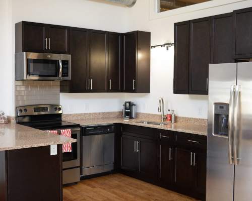 Kitchen with stainless steel appliances with double door refrigerator at Revolution Mill in Greensboro, North Carolina