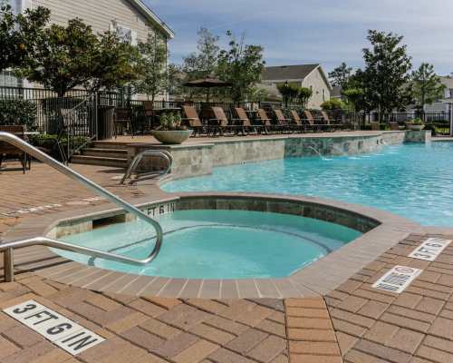 Resort-style swimming pool with multiple lounge chairs at Northchase Village in Houston, Texas