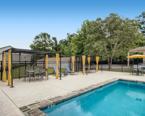 Resort-style swimming pool with lounge chairs at Leaf Stone Apartments in Covington,Georgia