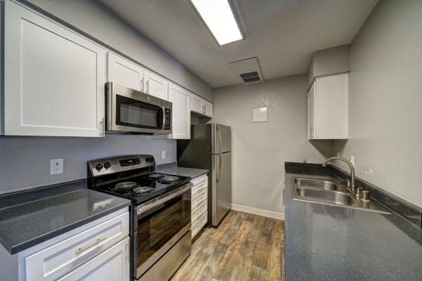 White renovated kitchen with stainless steel appliances at Parkside Commons Apartments in San Leandro, CA