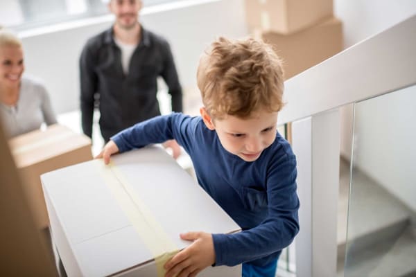 Child carrying a box upstairs at Owosso Mini Storage in Owosso, Michigan