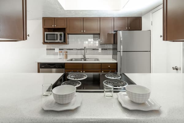 Brown Renovated Kitchen with stainless steel appliances at at Windgate Apartments in Bountiful, Utah