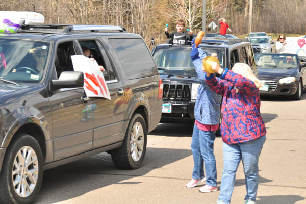 Cars driving down a local road for a rally near Deephaven Woods in Deephaven, Minnesota