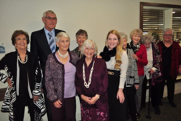 Residents and staff smiling and standing in a line at Deephaven Woods in Deephaven, Minnesota