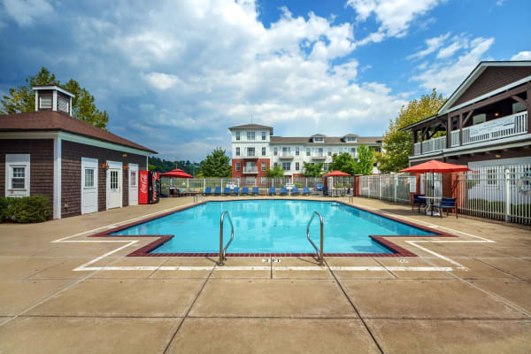 Pool with lots of lounge chairs at The Waterfront Apartments & Townhomes in Munhall, Pennsylvania