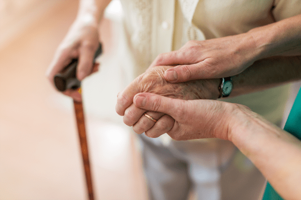a nurse holding a resident's hand at at Wesley Place on Honeysuckle in Dothan, Alabama