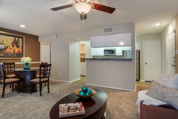 Living room and dining area with pass-through to the kitchen in an open layout model apartment home at Foundations at Edgewater in Sugar Land, Texas