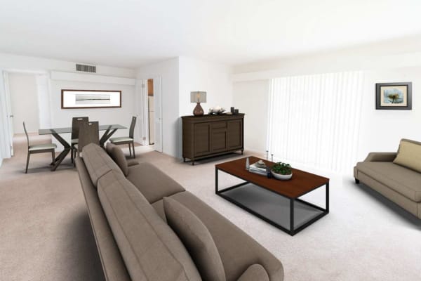 Spacious living room and dining area with plush carpeting in a model apartment home at Corliss Apartments in Phillipsburg, New Jersey