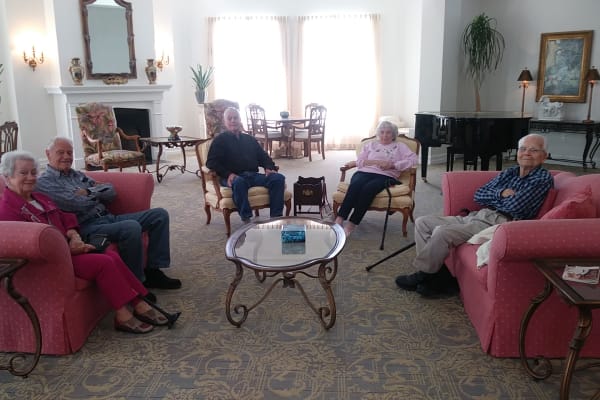 Group of resident sitting around a coffee table conversing at Mathison Retirement Community in Panama City, Florida