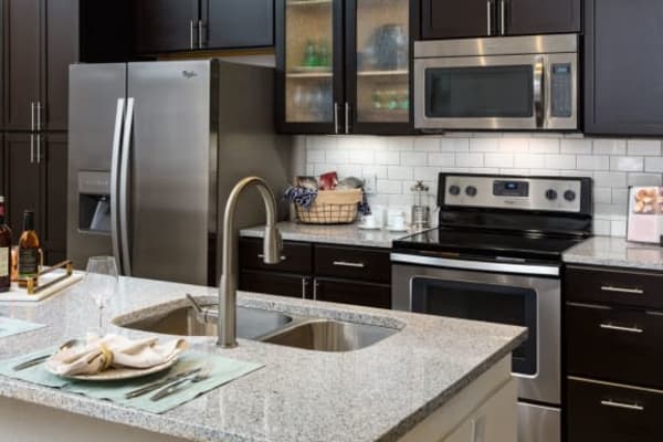 Luxury kitchen with granite countertops, custom cabinetry, and stainless steel appliances at Haywood Reserve Apartment Homes in Greenville, South Carolina