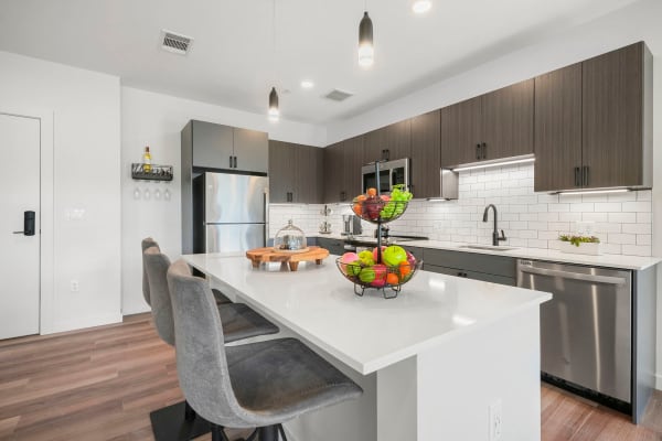 Modern kitchen with quartz countertops and custom cabinetry in a model apartment at Anden in Weymouth, Massachusetts