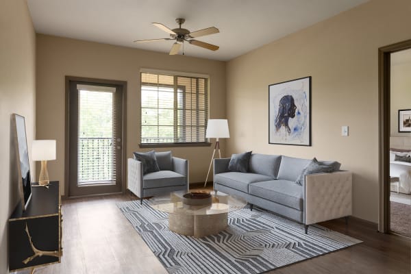 A furnished living room with ample, soft natural light at The Addison at South Tryon | Apartments & Townhomes in Charlotte, North Carolina