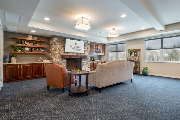 Resident lounge area with brick fireplace and large television at The Pillars of Grand Rapids in Grand Rapids, Minnesota