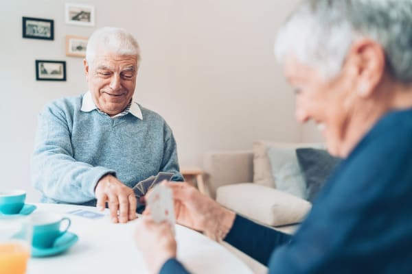 Independent senior couple playing cards at Vista Prairie at Garnette Gardens in Redwood Falls, Minnesota 