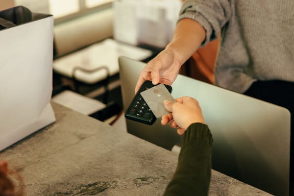 Resident handing over her credit card to a cashier at a downtown boutique near Canyon Grove in Grand Prairie, Texas