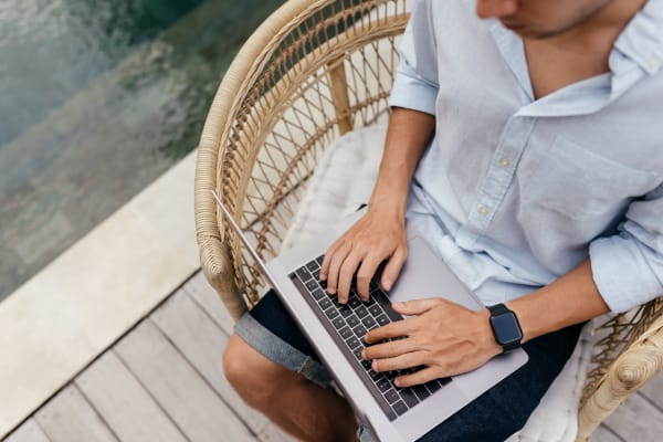 Resident getting some work done on a laptop near the swimming pool at The Fitz Apartments in Dallas, Texas