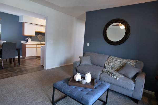 Retro-modern furniture and classic decor in a model home's living area at Hamptons of Norton Shores in Norton Shores, Michigan