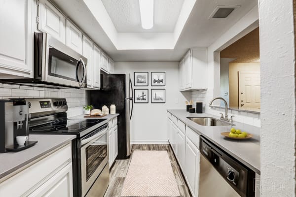 Kitchen with appliance at Embry Apartments in Carrollton, Texas